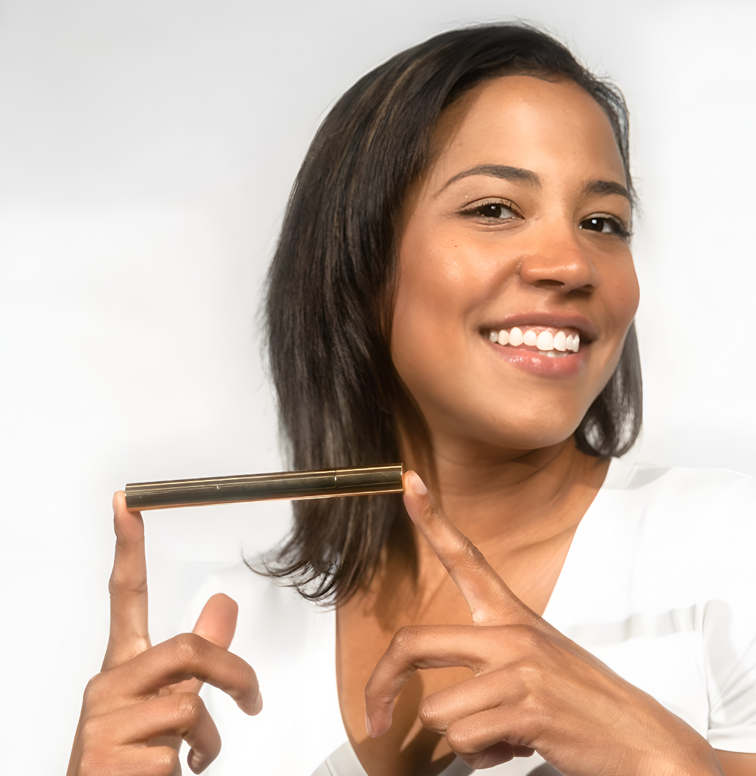 Woman holding a whitening pen while smiling in a white background