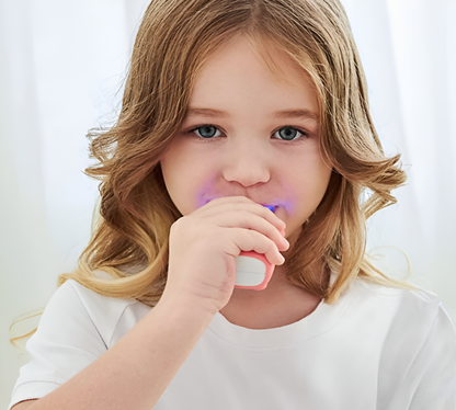 Young blonde girl using an electric U-brush against a white background